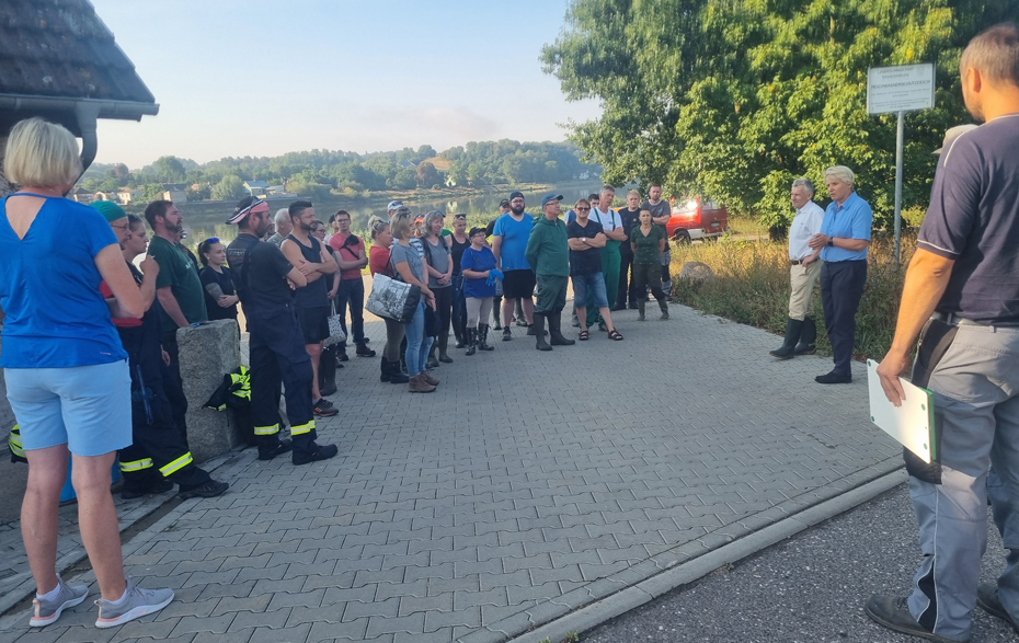 Foto: Gruppe steht im Kreis vor der Oder