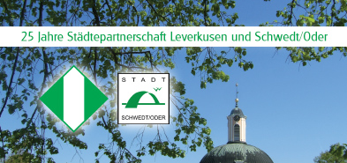 Text „25 Jahre Städtepartnerschaft Leverkusen und Schwedt/Oder“ und Stadtsignets vor blauem Himmel und Bäumästen und dem Berlischky-Pavillon-Dach