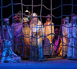 Foto: Opernsängern in Kostümen hinter Gittern aus Seilen