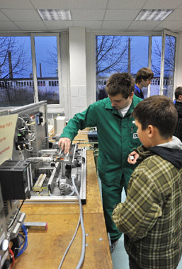 Foto: Ein Auszubildender zeigt einem Schüler seinen Arbeitsplatz.