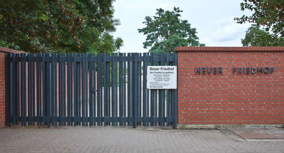 Foto: Gittertor und Schriftzug an der roten Klinkermauer