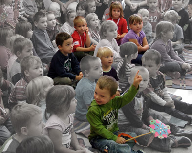 Schwarz-Weiß-Foto mit sitzenden Kinder, 6 sind farbig hervorgehoben
