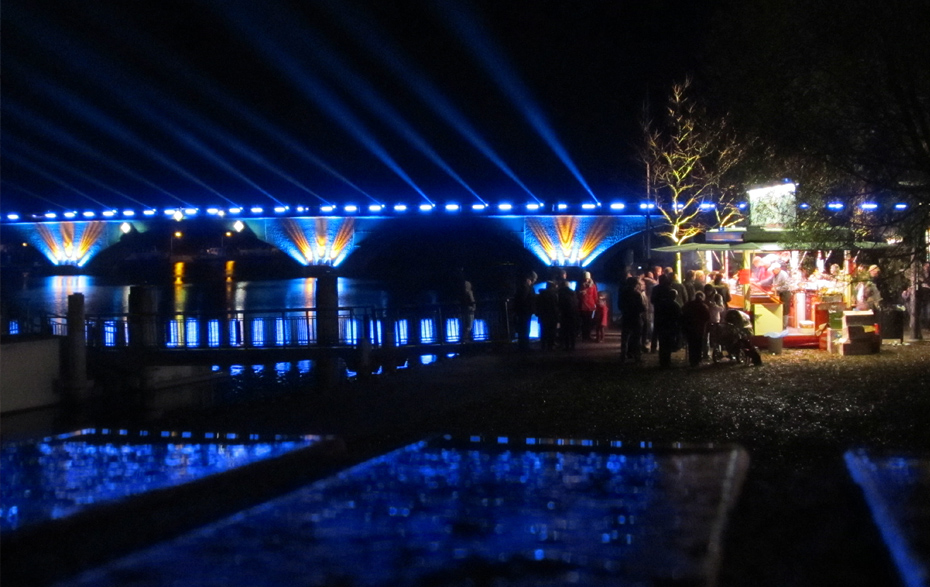 Foto: beleuchtete Stadtbrücke und Stand am Bollwerk im Dunkeln