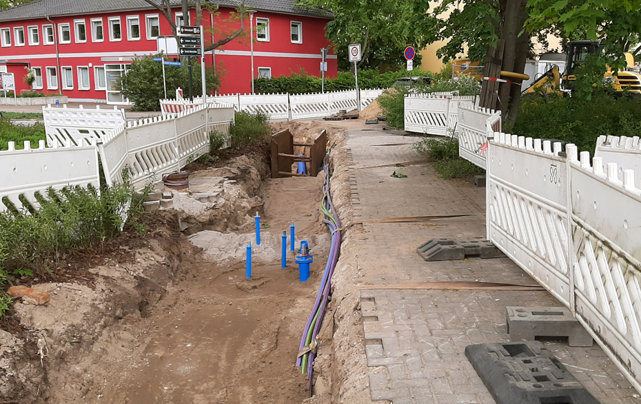 Foto: abgesperrte Baustelle eines Gehweges mit Leitungen