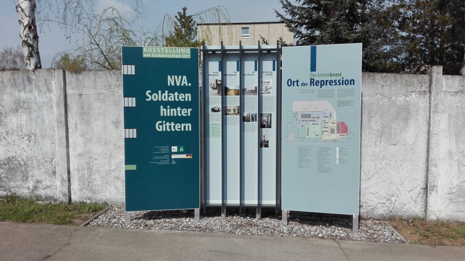 Tafel mit drei Flächen auf denen Fakten und Pläne über das ehemalige DDR-Militärgefängnis informieren