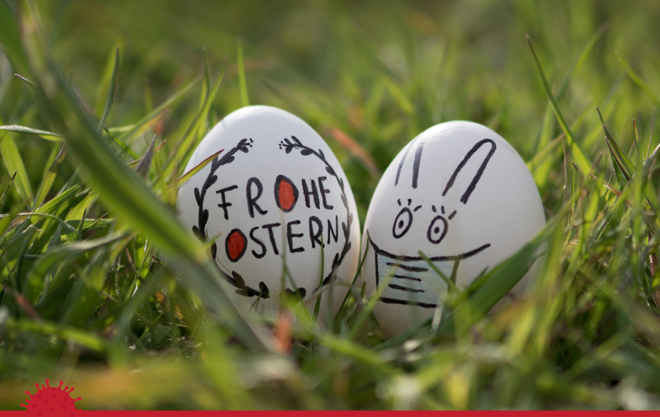 Foto: 2 bemalte Eier im Gras mit dem Gruß „Frohe Ostern“