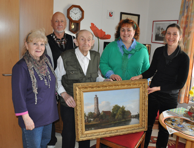 Foto: Fünf Personen freuen sich über das Gemälde