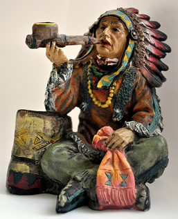 Foto: farbige Skulptur eines sitzenden Indianers mit Pfeife