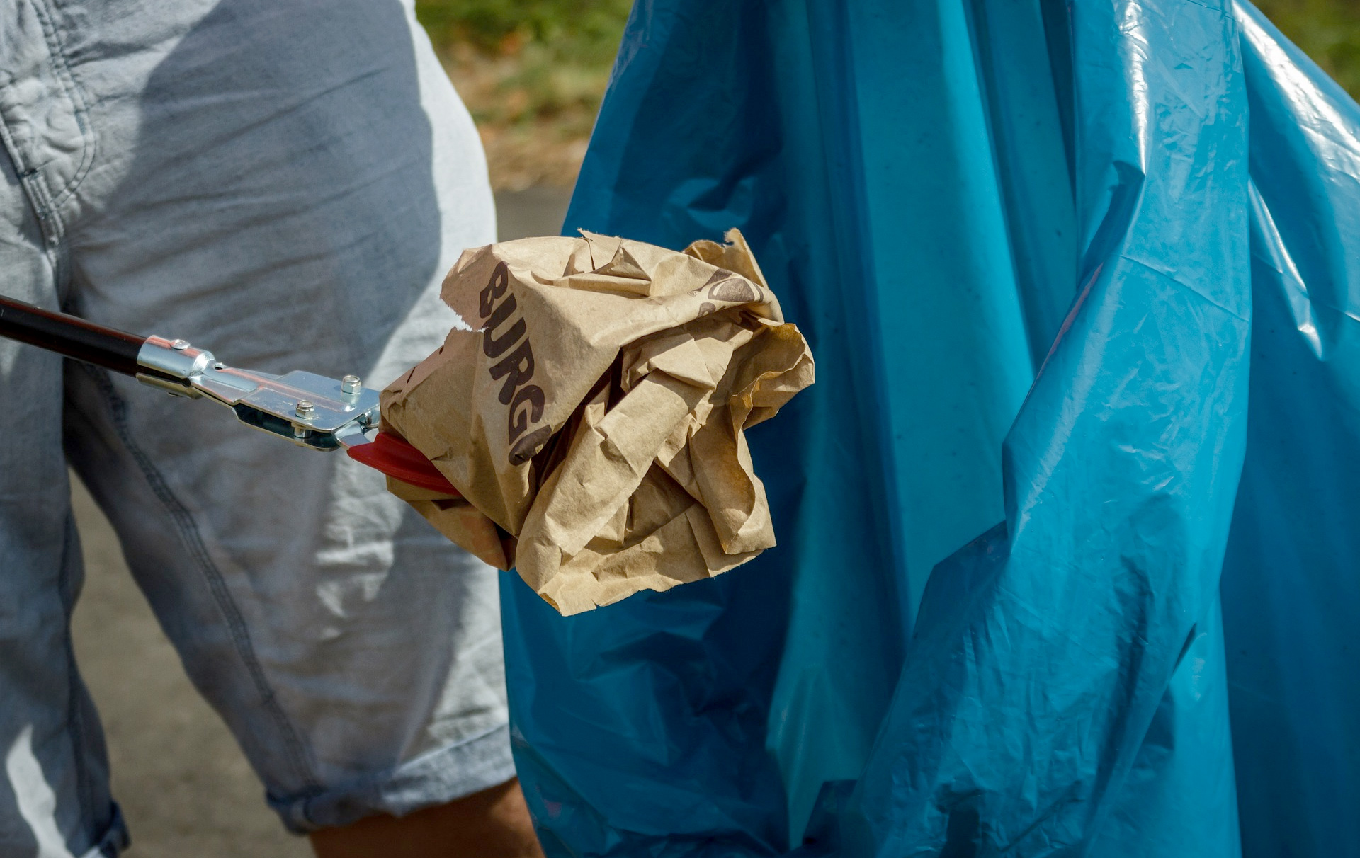 Foto: Müll mit der Zange erfasst und auf dem Weg in den Müllbeutel