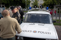 Foto: ein Volkspolizei-Auto und Interessenten im GEspräch