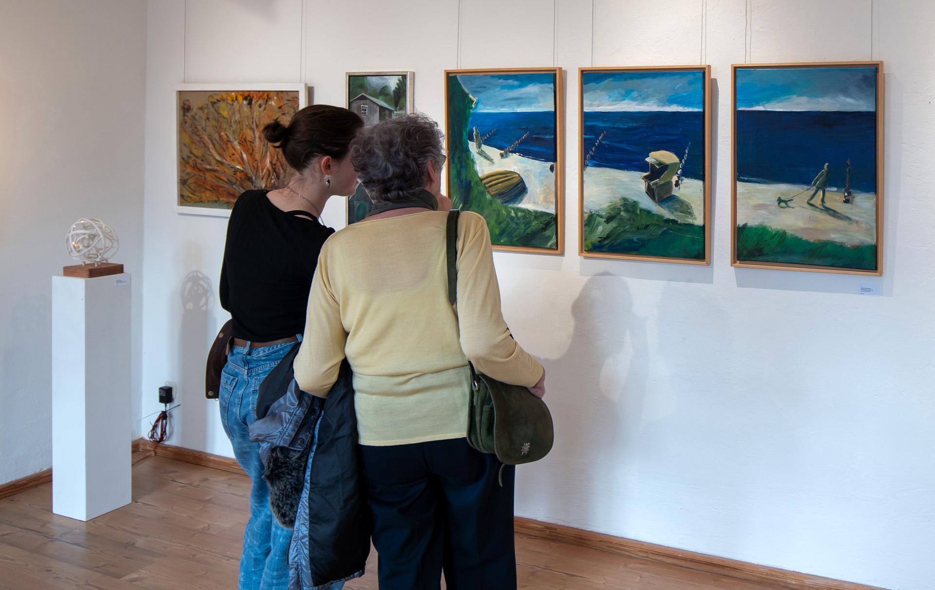 Foto: 2 Besucherinnen betrachten die Kunstwerke an der Wand Foto: 2 Besucherinnen betrachten die Kunstwerke an der Wand