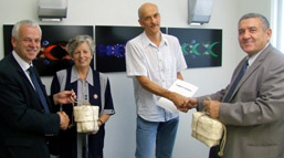 Foto: 4 Personen bei der Übergabe des Integrationspreises 2012 mit einem Kalit als Geschenk.