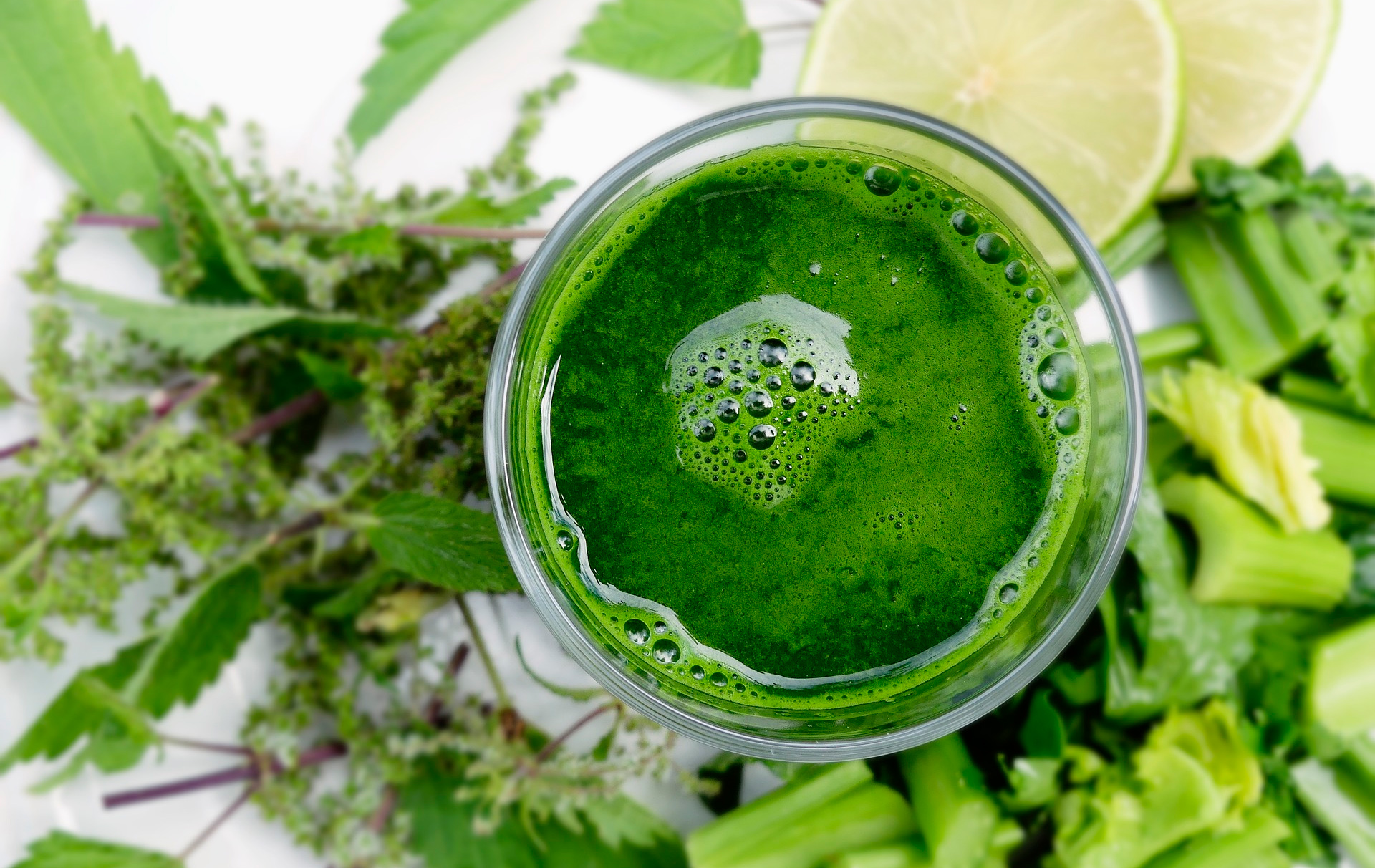 Foto: grüner Smoothie im Glas und die Zutaten drumherum