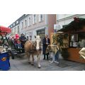 Foto: Der Bürgermeister sitzt mit Kíndern und dem Weihnachtsmann in einer Kutsche und fährt an den Marktständen vorbei.