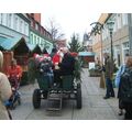 Foto: Der Bürgermeister sitzt mit Kindern und dem Weihnachtsmann in einer Kutsche und fährt durch die Vierradener Straße.