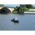 Foto: Neptun und Nixe in einem blauen Boot auf dem Kanal vor der Stadtbrücke