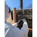 Foto: Person im Schutzanzug arbeitet mit einem Werkzeug am Relief