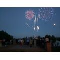 Foto: Publikum steht am Ufer und betrachtet das Feuerwerk.