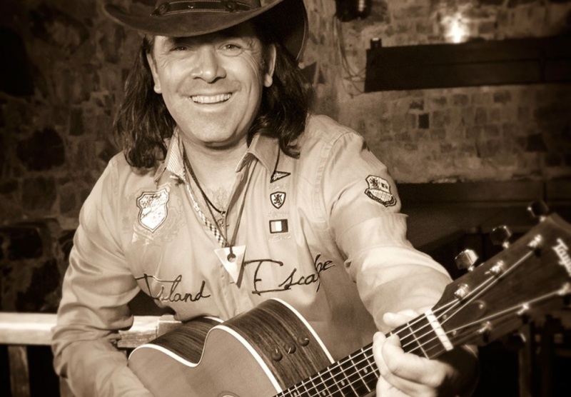 Musiker Peter Leon mit Gitarre und Cowboy-Hut