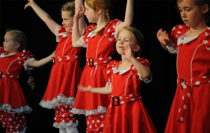 Foto: tanzende Mädchen in roten Kleidern