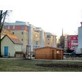 Foto vom 20. Februar 2012: neue Wohnblöcke und eine Holzhütte, im Hintergrund die katholische Kirche