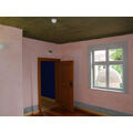 Foto: Innenraum mit rosefarbener Wandfarbe, im Fenster ist die Mikwe zu sehen