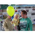 Foto: Mädchen auf dem Arm des Vaters mit einem gelbgrünen Luftballon.