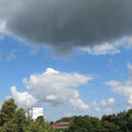 Foto vom 21. August 2013: weiße und graue Wolken über Bäumen und Dächern der Lindenallee