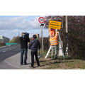 Foto: zwei Stadtbedienstete beim Anbringen des Schildes