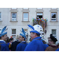 Foto: Karnevalisten lachen, im Hintergrund ist der Bürgermeister auf dem Balkon zu sehen.