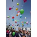 Foto: viele bunte Luftballons fliegen los