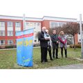 Foto: 4 Personen neben der Flagge