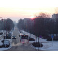 Foto vom 6. Februar 2012: Blick in die Rosa-Luxemburg-Straße mit Bus und PKW und der aufgehenden Sonne im Hintergrund