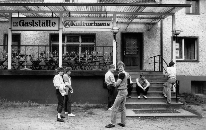 Foto in Schwarz-Weiß: Jugendliche vor einem Kulturhaus-Eingang