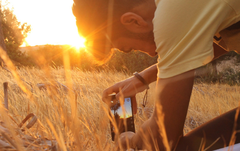 Foto: Junge beim Fotografieren der Sonne aus einer tiefen Position