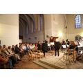 Foto: Kircheninnenraum mit Instrumentalmusikern und Publikum