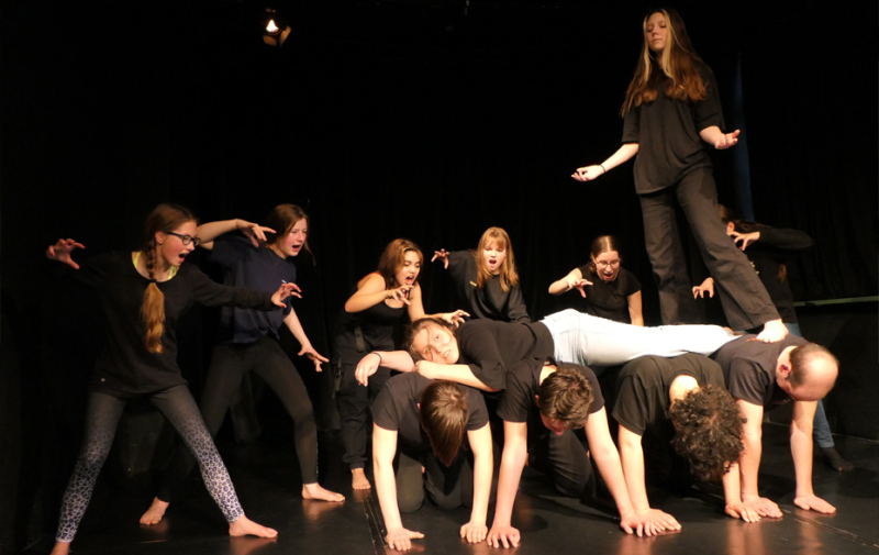 Foto: 12 junge Schauspieler und Schauspielerinnen in Schwarz mit unterschiedlichen Haltungen