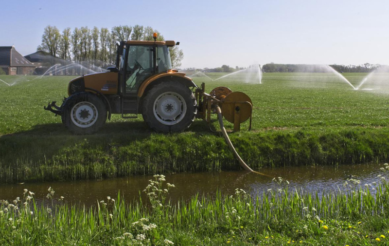 Foto: Traktor mit Pumpe bei der Entnahme von Wasser aus einem Graben